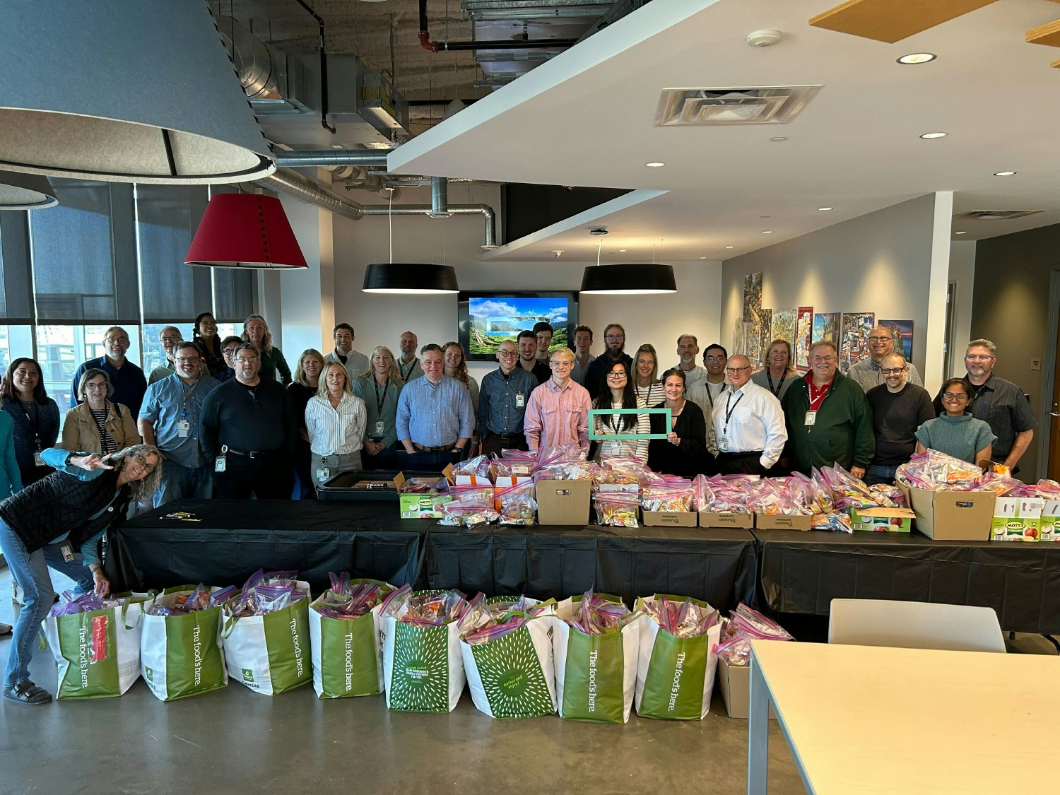 All Team Meeting taking place in HPE's Houston headquarters lobby featuring a live band, host, and fun theme.