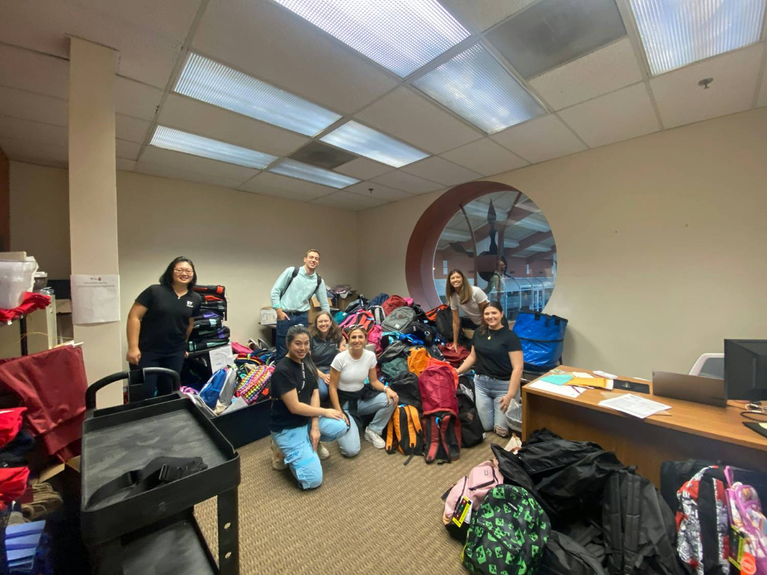 Basis Giving Tree members gathering with other professionals to volunteer with Operation Backpack. 