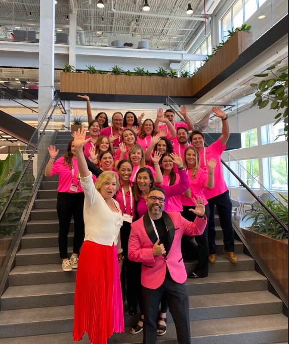Teammates posing with our CEO on the stairs in our headquarters.