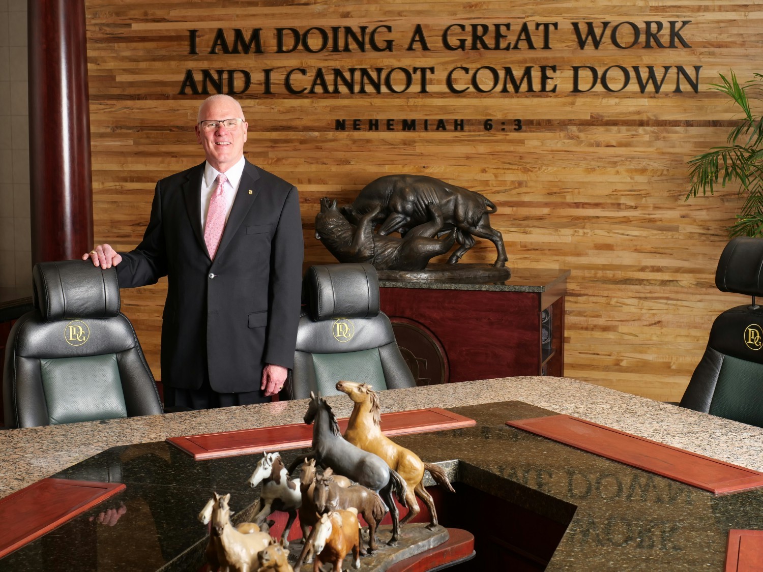 President and CEO of Directors Investment Group, Kris Seale, amid symbols of company core values.