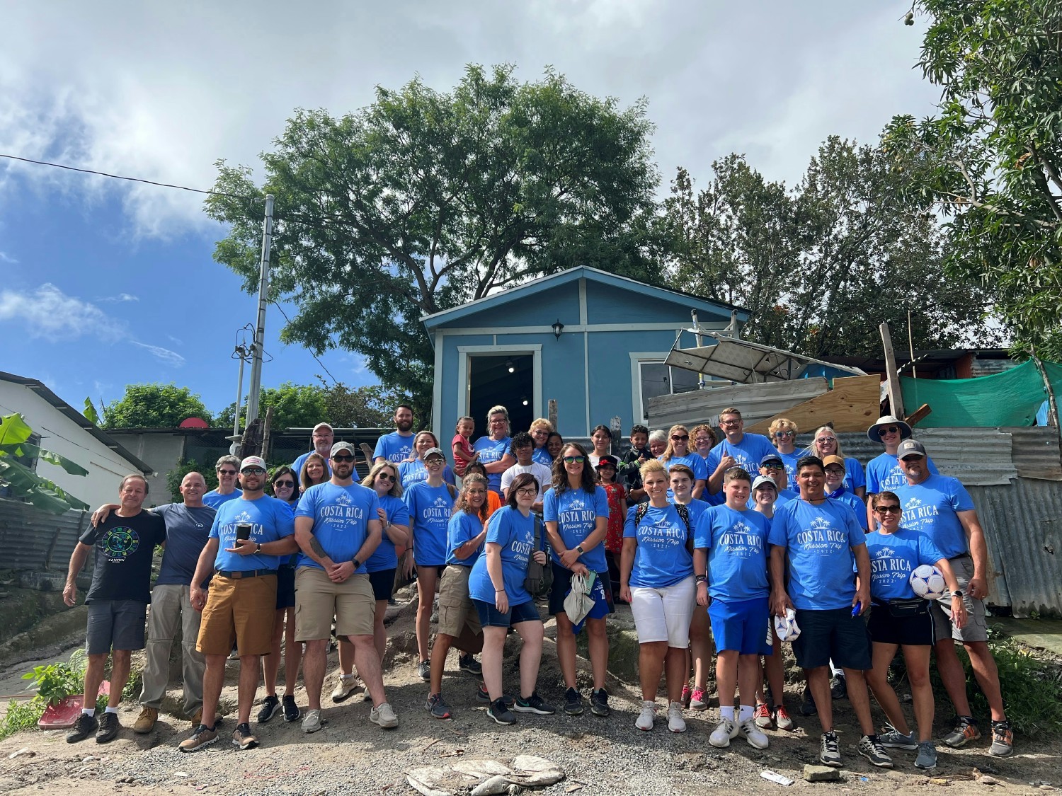 Employees gather around the house built for a family during the annual mission trip to Costa Rica! 