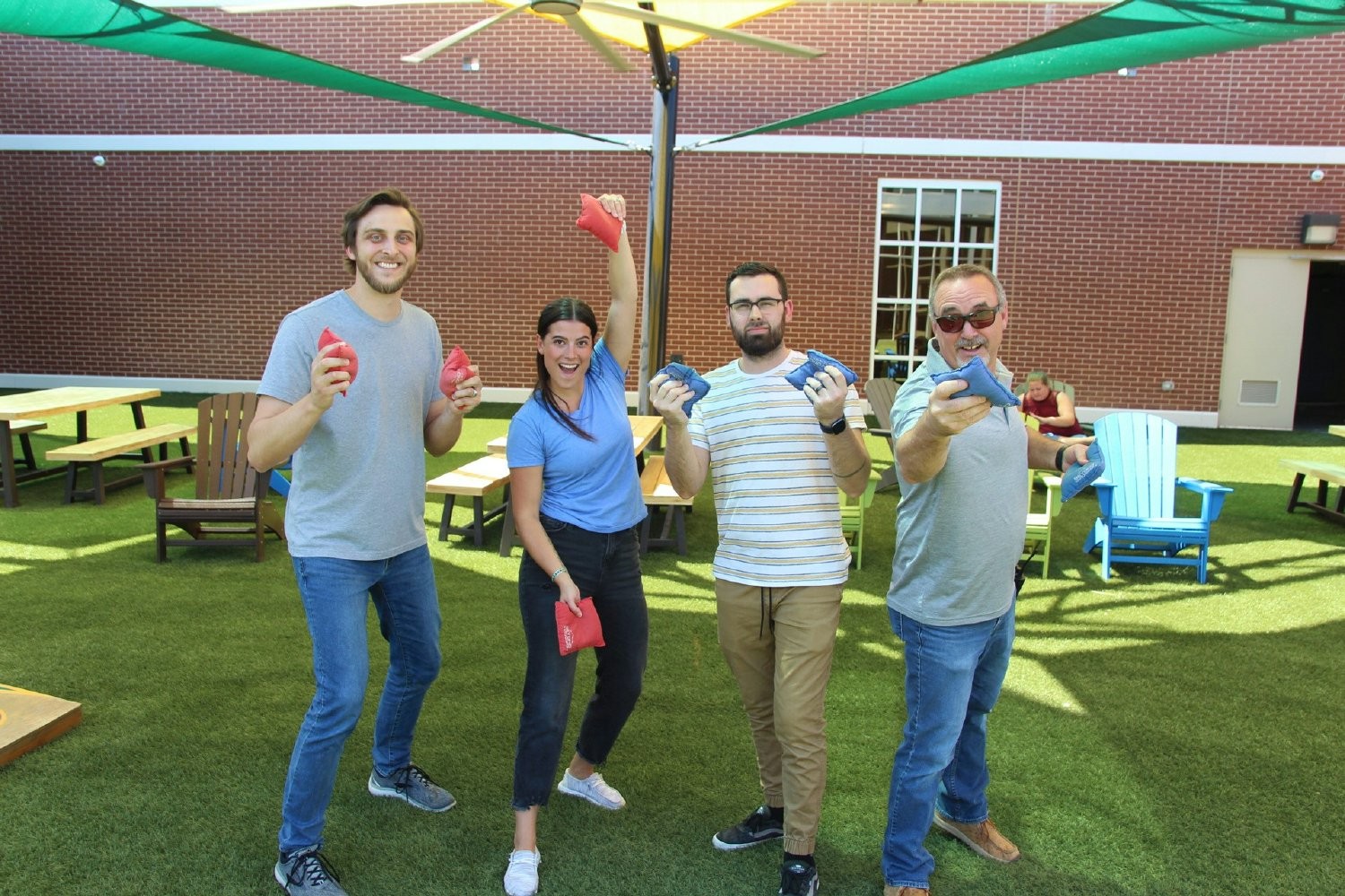 Employees express their anticipation for the company cornhole tournament in the DIG courtyard! 