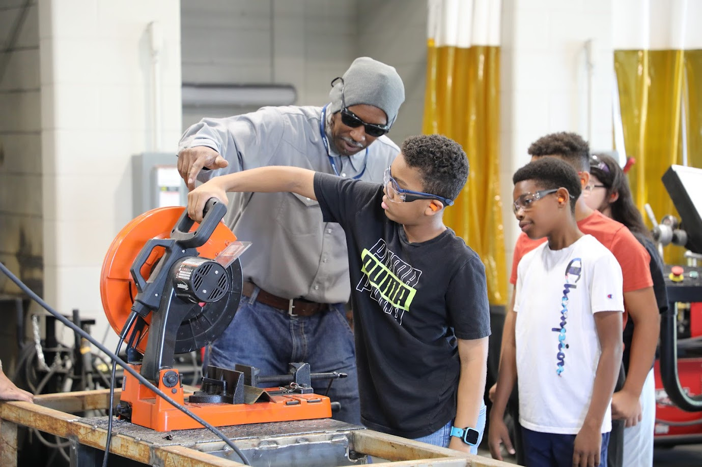 Trade and Industry instructor showing future students how to properly and safely operate a table saw. 
