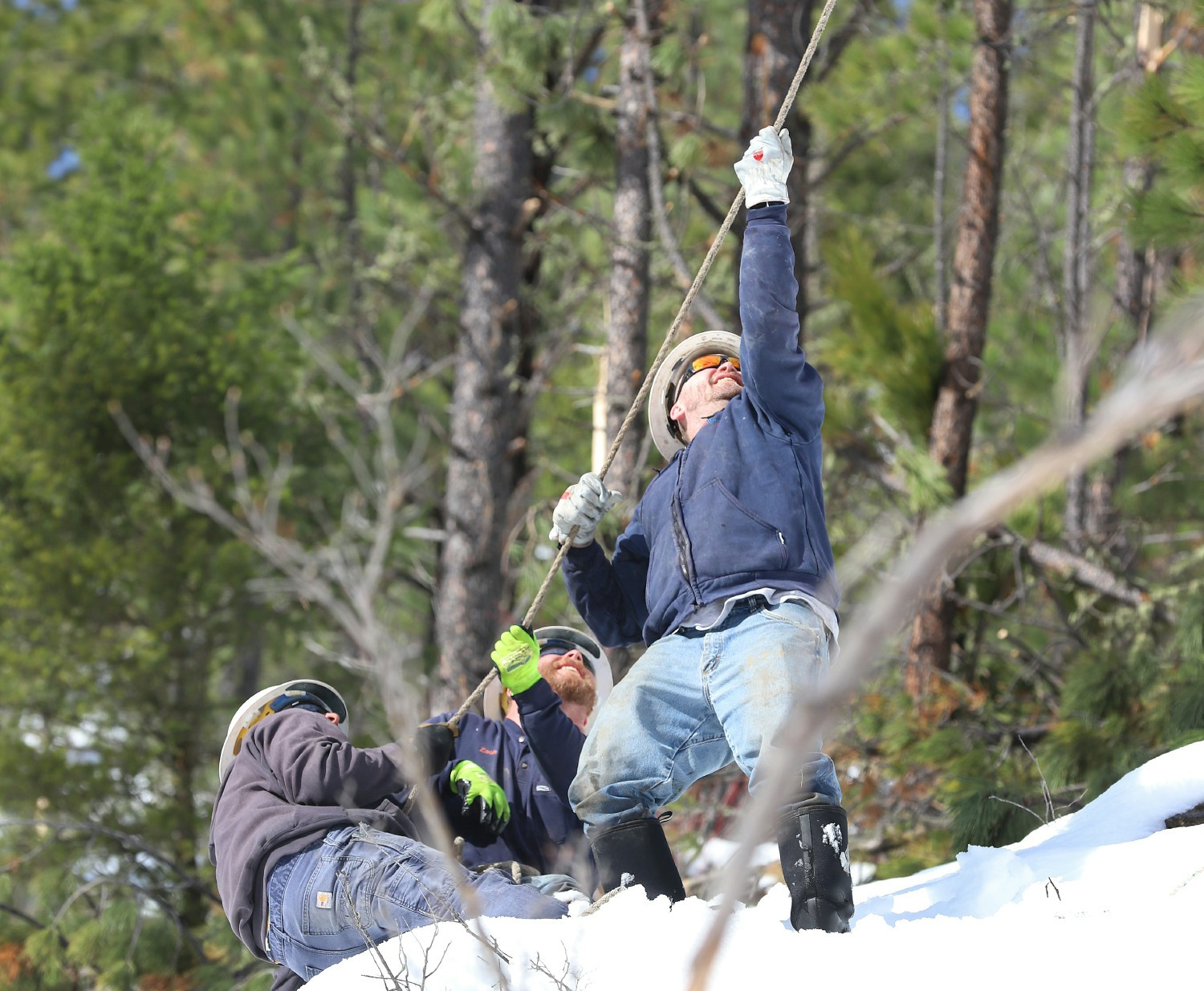 A line crew works to repair damage to a powerline after a storm in Monarch, Montana.