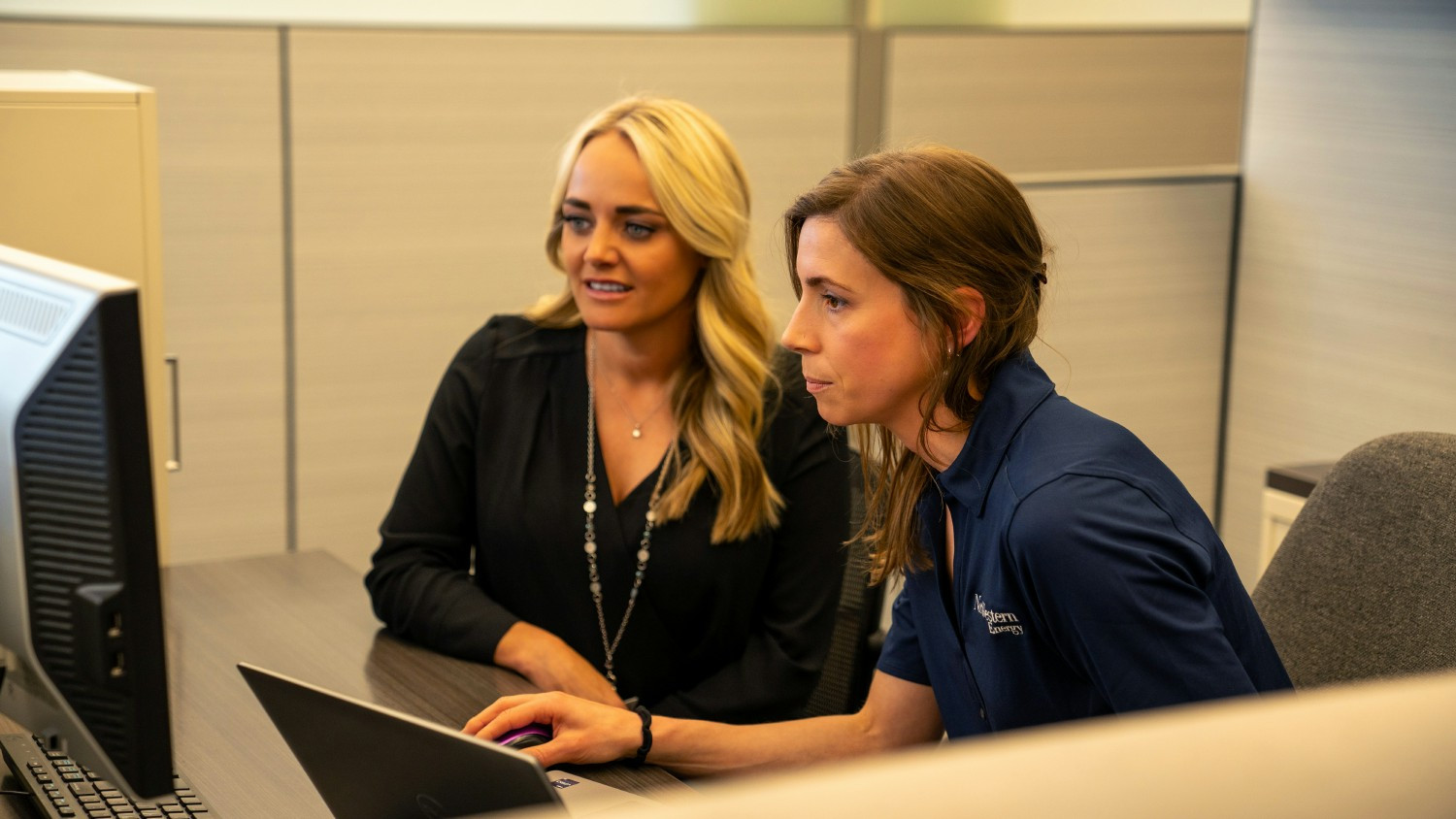 Two NorthWestern Energy employees collaborate to use wildfire data for mapping.