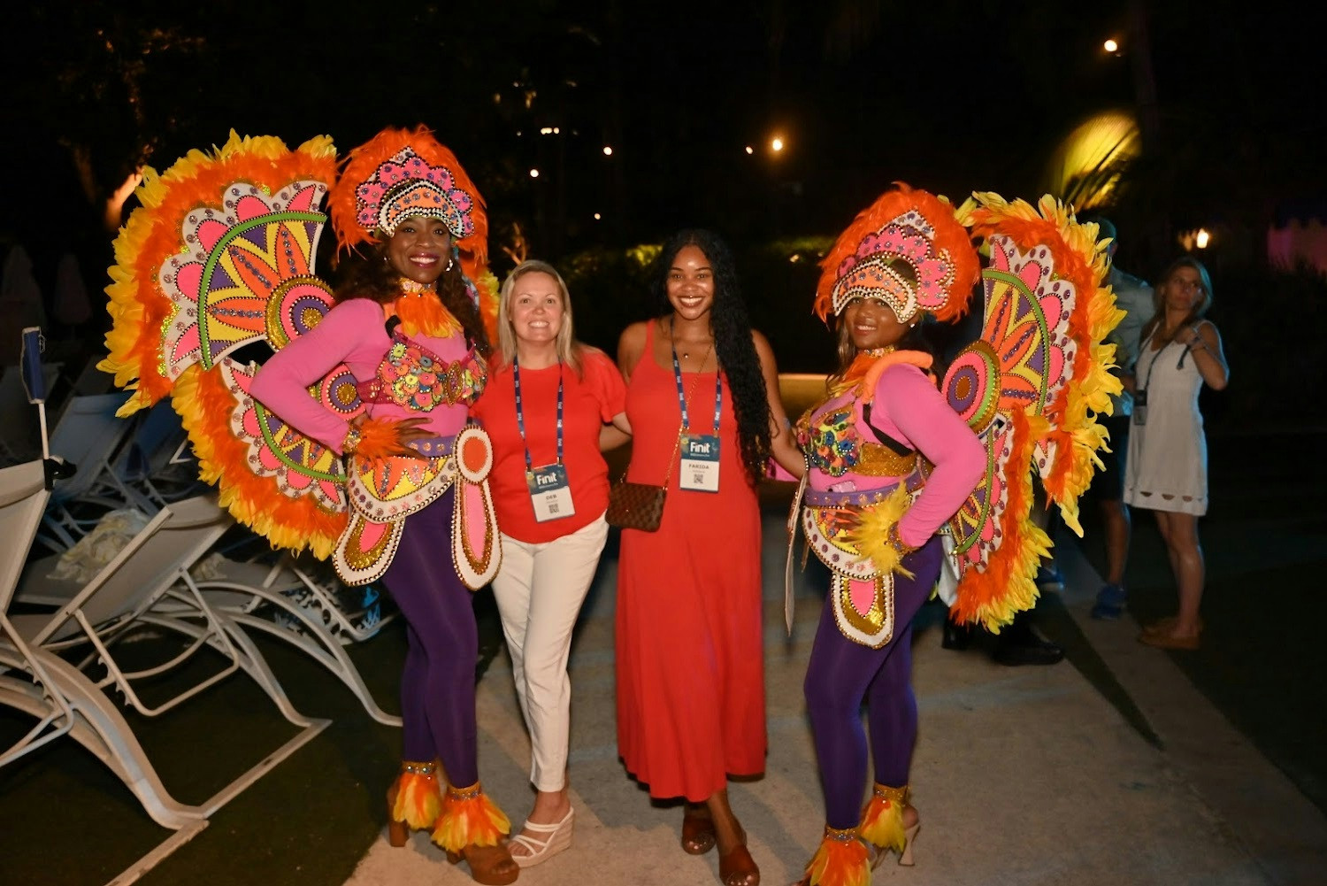 Two Finitians are warmly greeted by two traditional Bahamian Junkanoo dancers during our company trip.