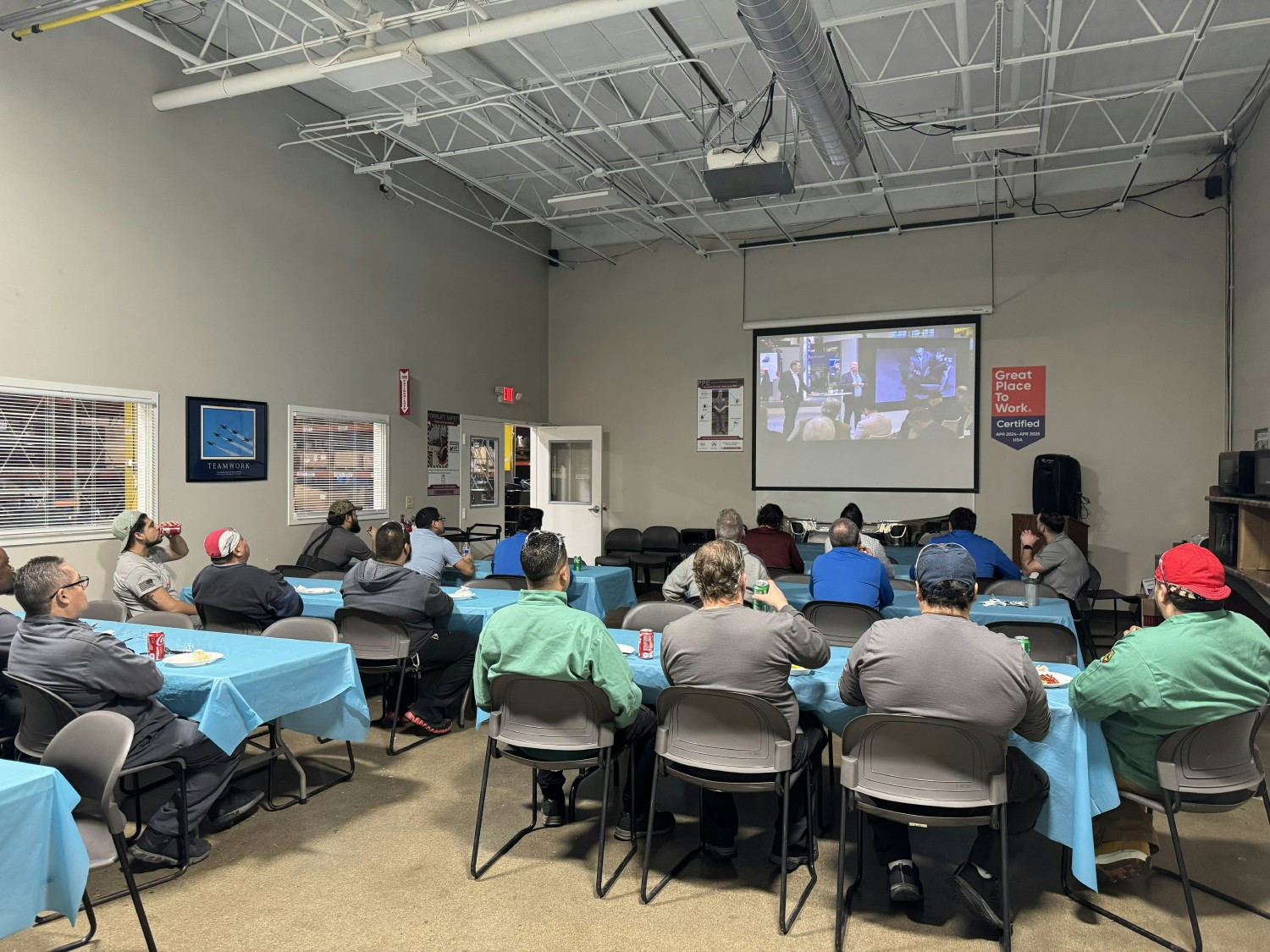 Hendrickson employees enjoying pizza while they watch a live launch of a customer's new product.