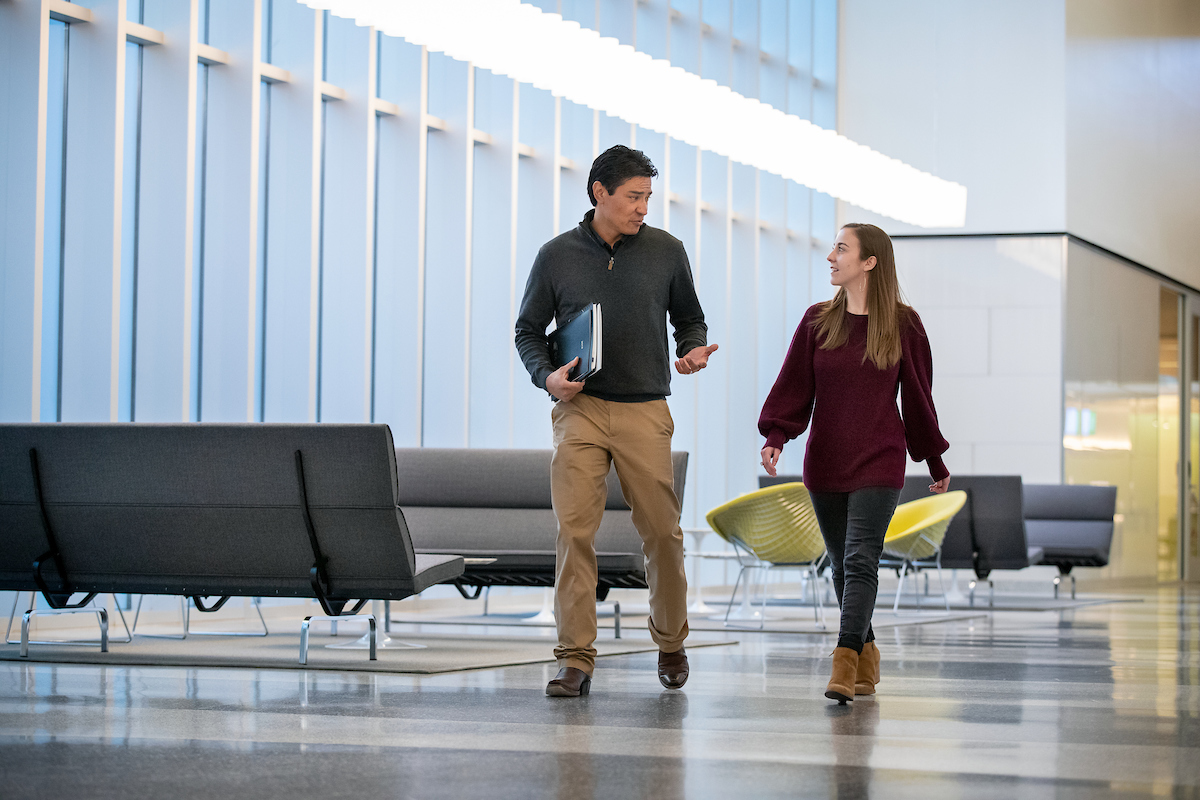 Employees catching up while walking through Employees' Center