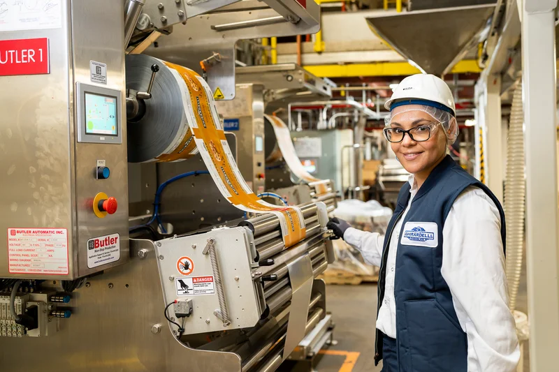 Ilda inspects bagging equipment. Our awesome production team makes sure our chocolate is made to our high standards.
