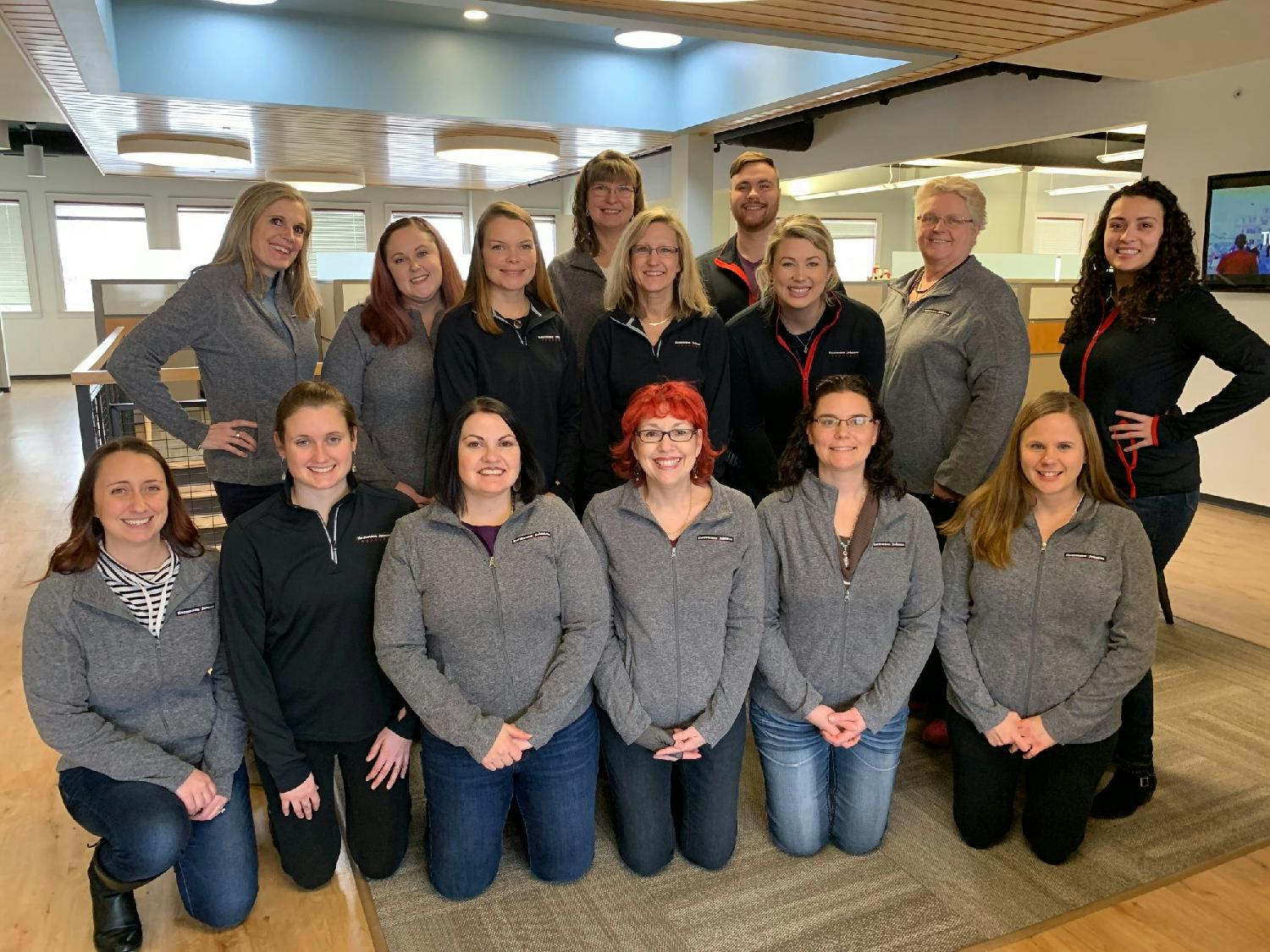 Wellness participants showing off the jackets they earned for participating in the program (pre-covid)