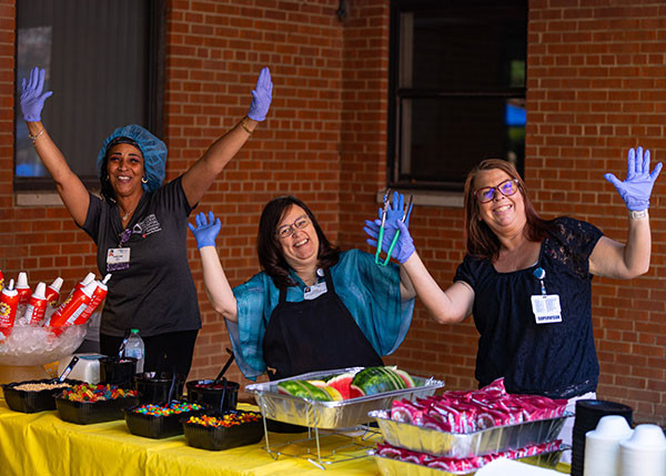 Managers serve staff at the company picnic.