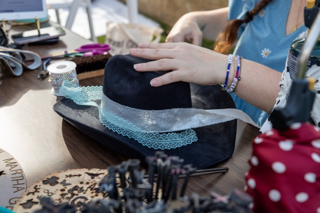Customizing cowboy and cowgirl hats to support our charity of the year.