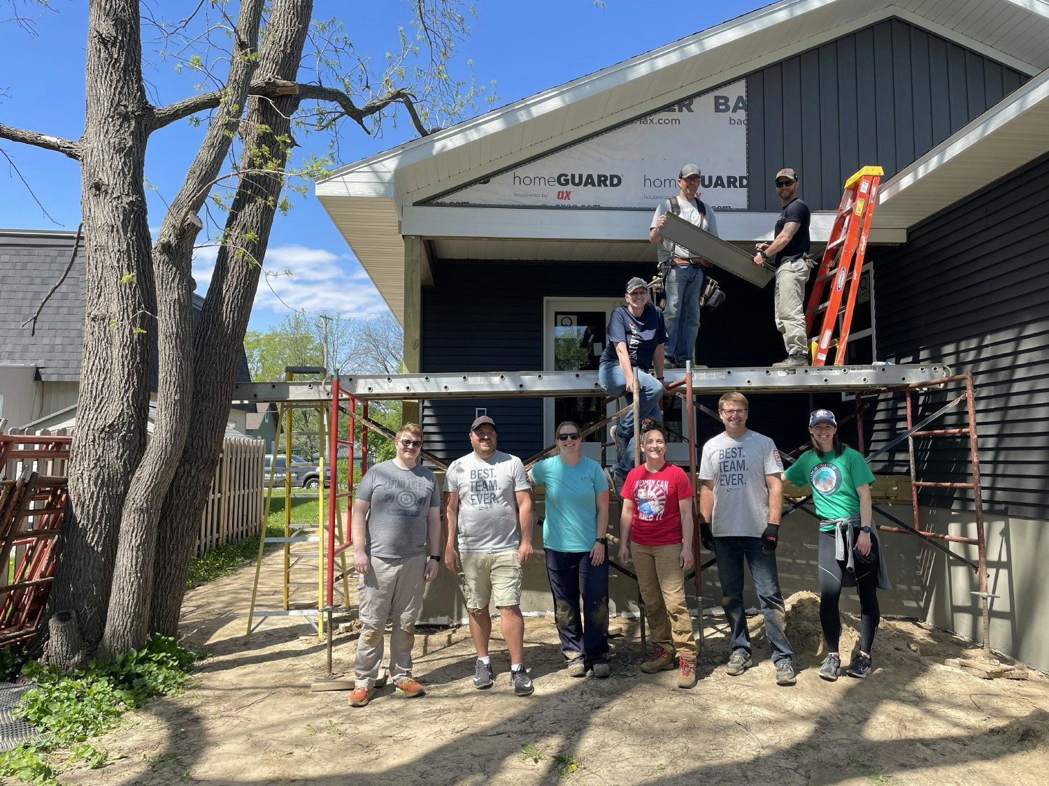 A volunteer crew putting siding up at a Habitat for Humanity build.