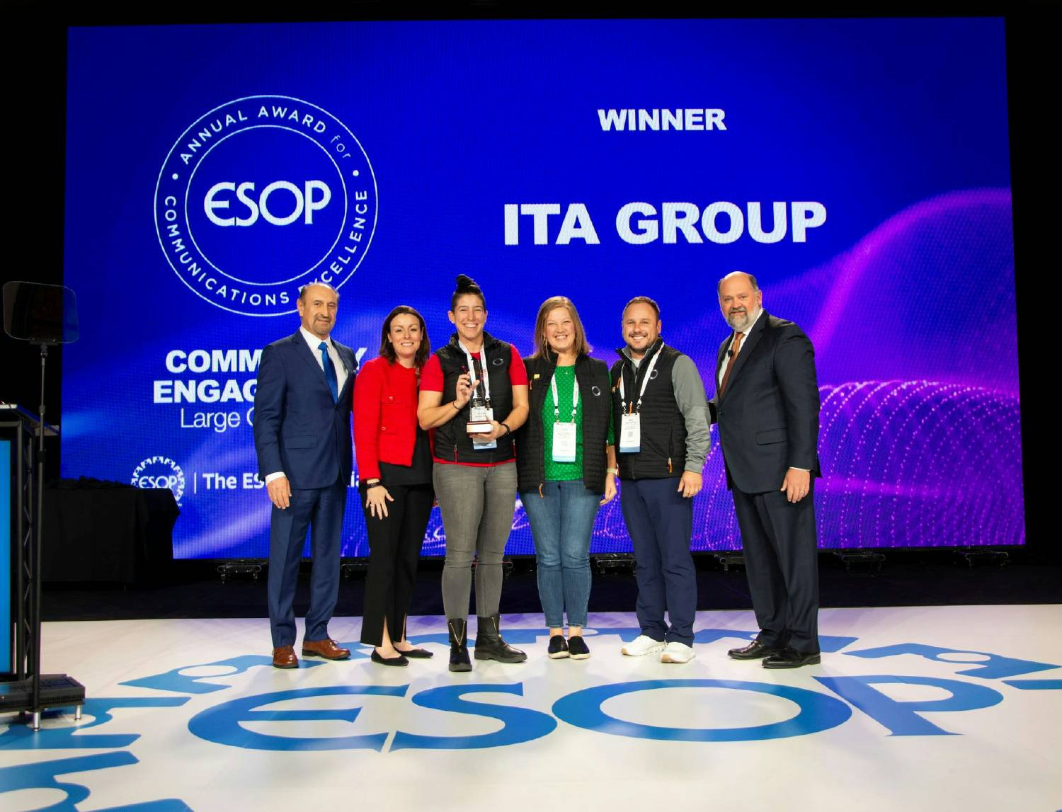 Team members accepting an award for employee ownership communication excellence.