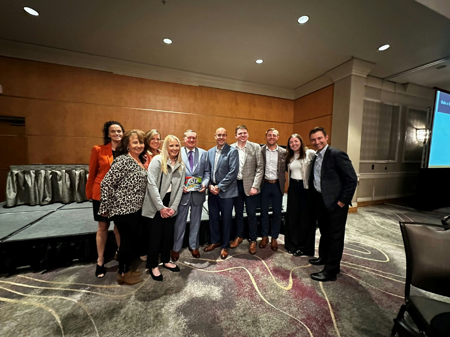 The team celebrating with our President and CEO after winning a philanthropy award.