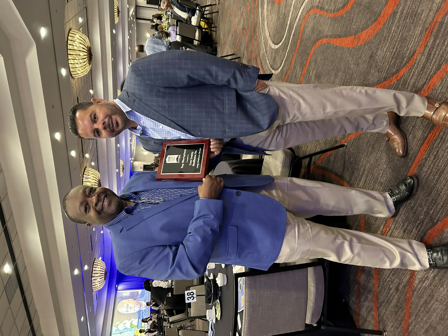 Colin McDonald, CHRO and Jerry Chico, GVP Procurement accept an award for Cross Country for South Florida Top Workplaces