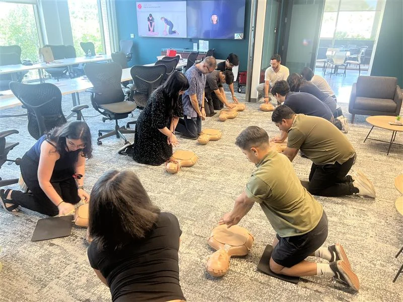 Employees practicing CPR in a workplace training session