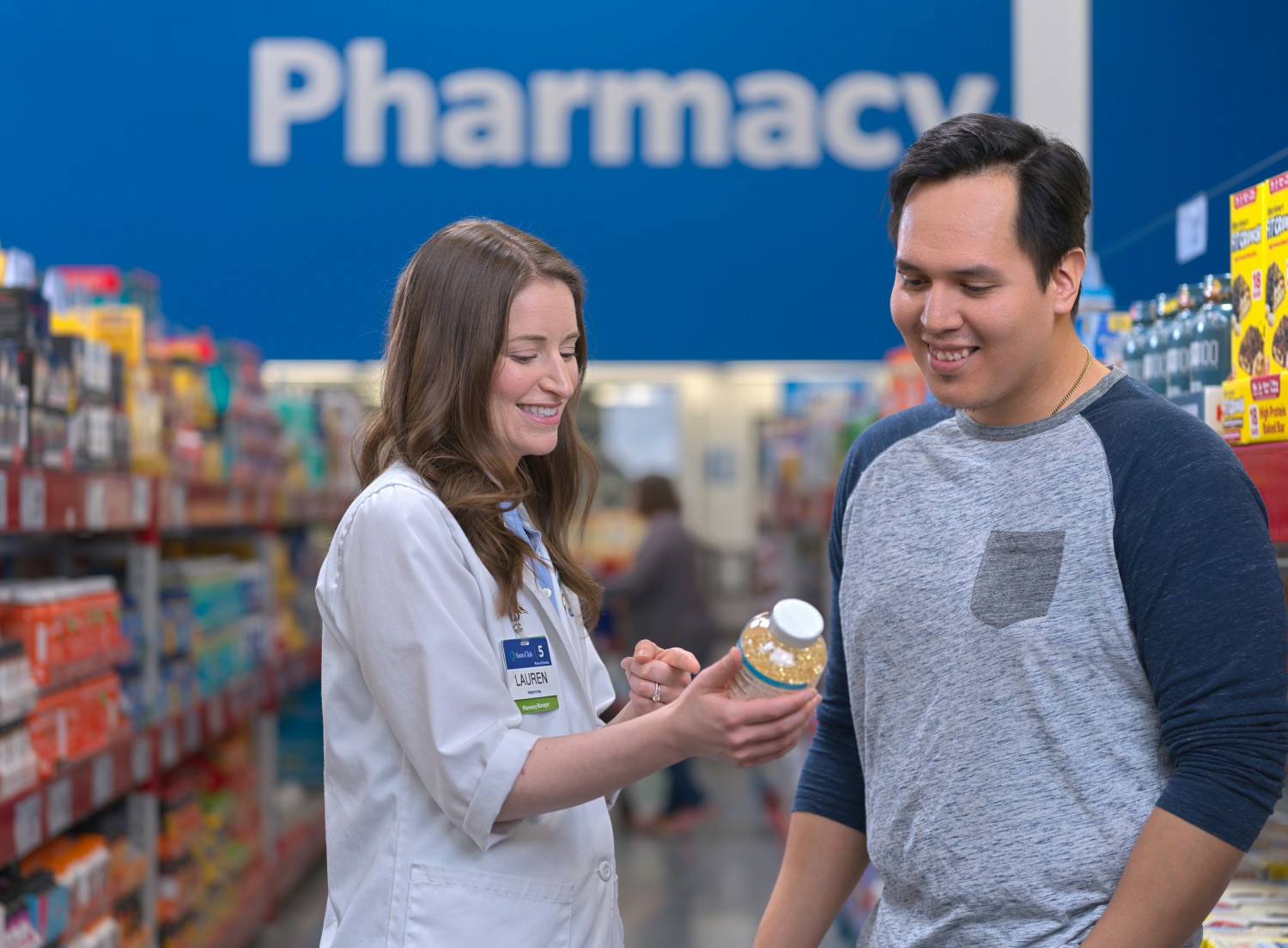 Pharmacy associate helping member.