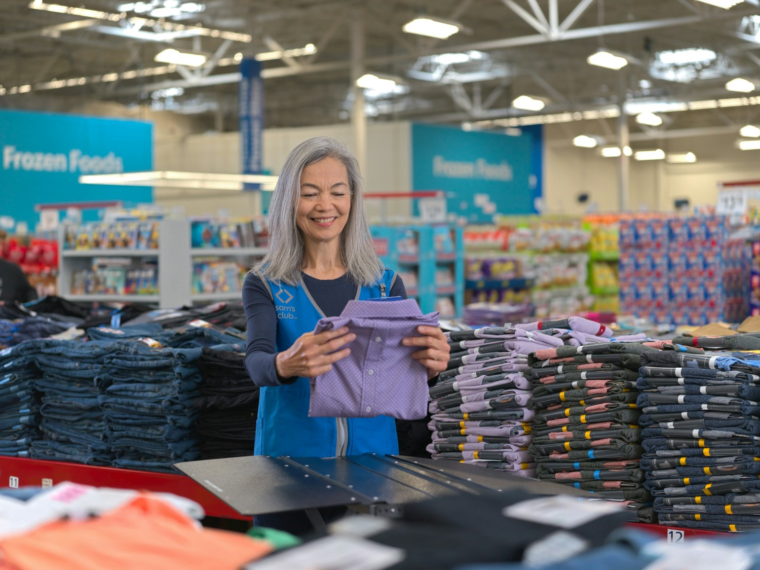 Sam's Club associate folding clothes.