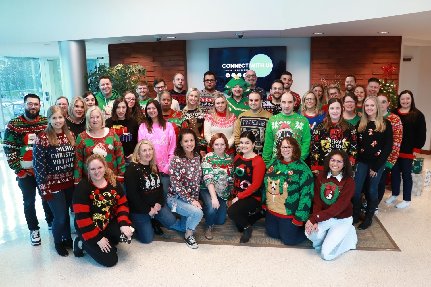 Festive employees take a photo op with their best ugly sweaters.