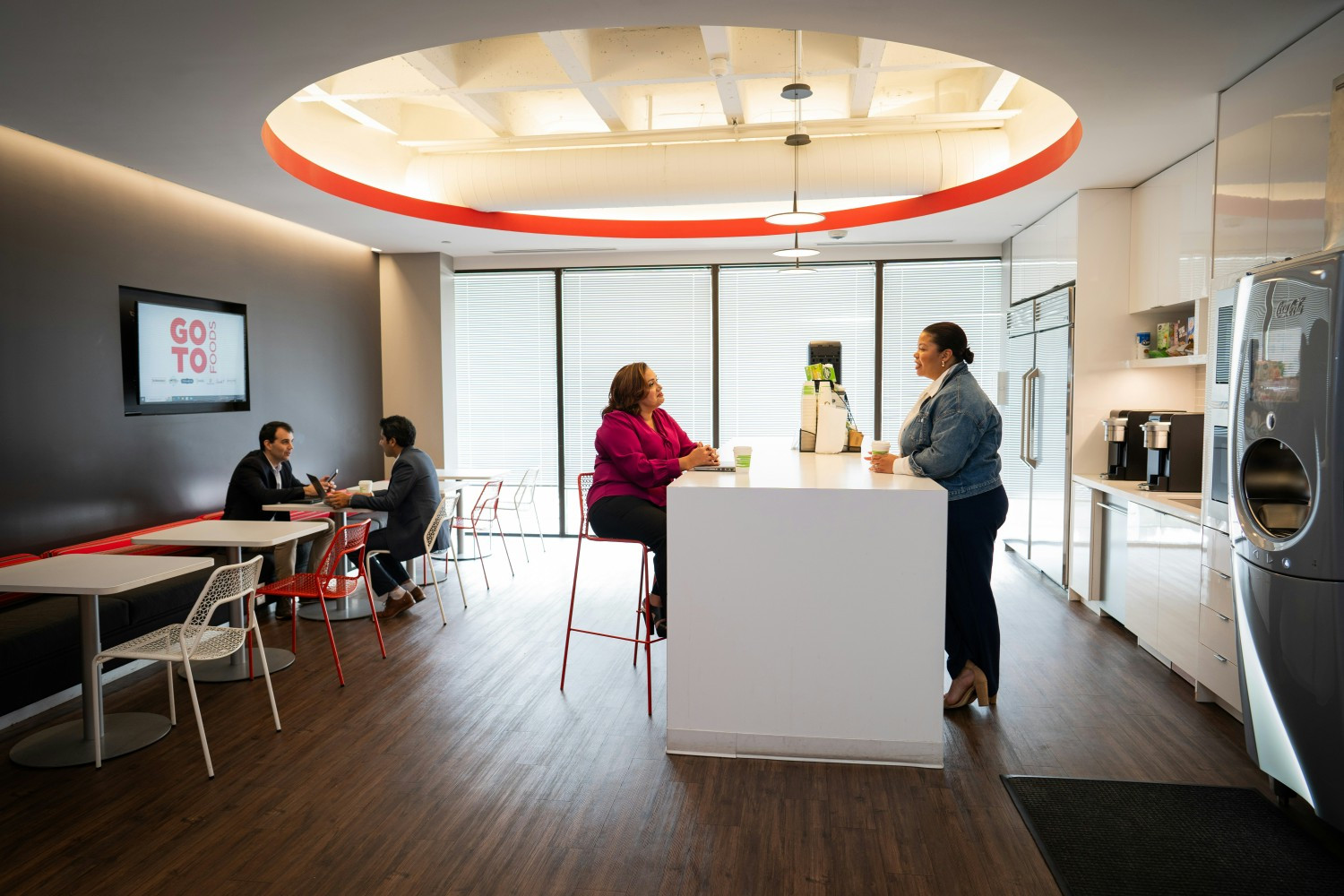 A group of GoTo Foods employees having a conversation in one of the staff kitchens at the GoTo Food office headquarters.
