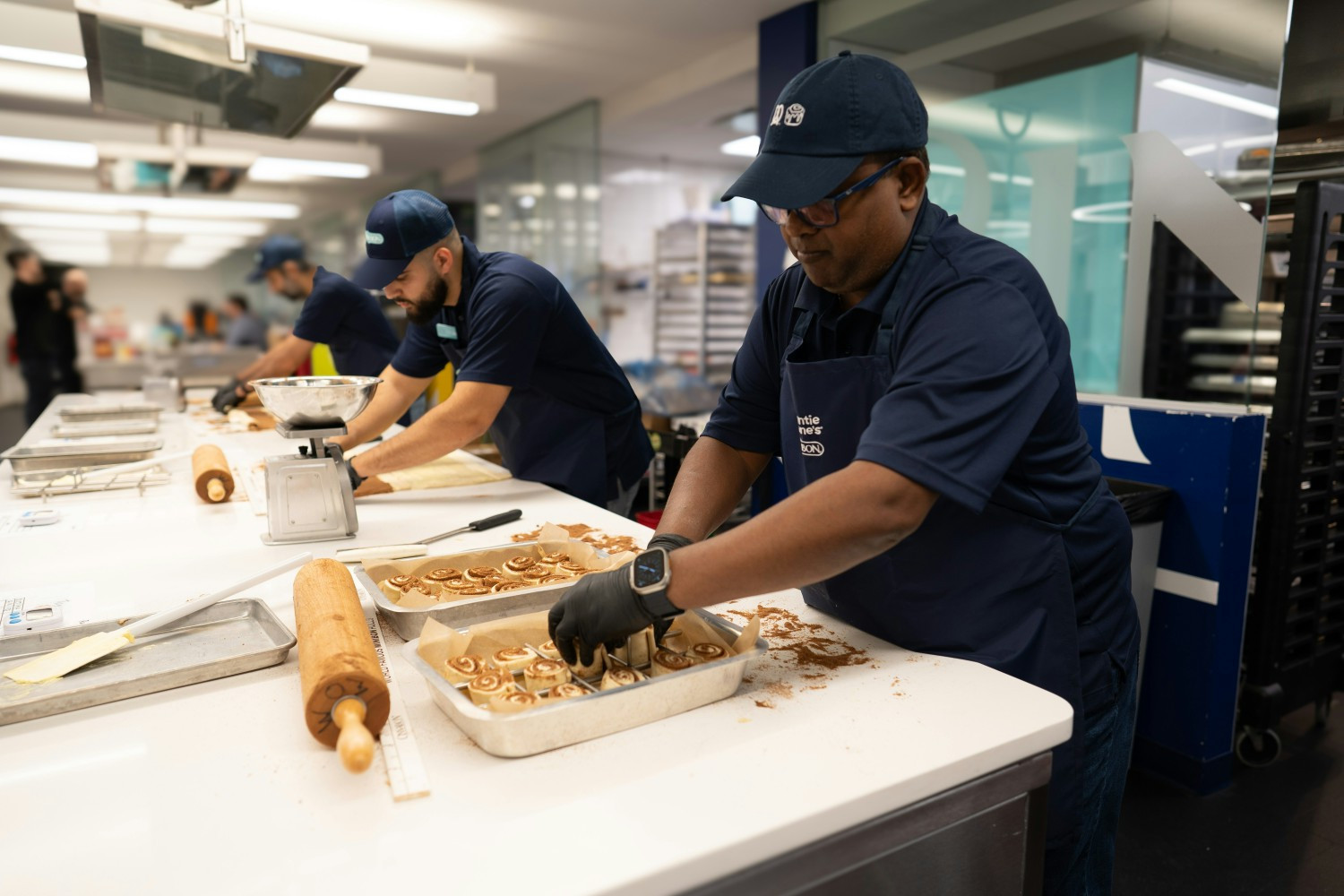A team of bakers is preparing the traditional Cinnabon in the test kitchen at GoTo Foods headquarters. 