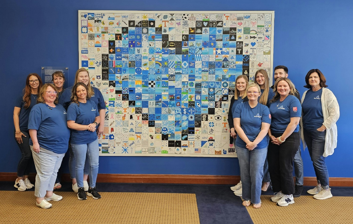 Our HR team in front of the blue heart art project—created with a tile from every SmartBank associate.