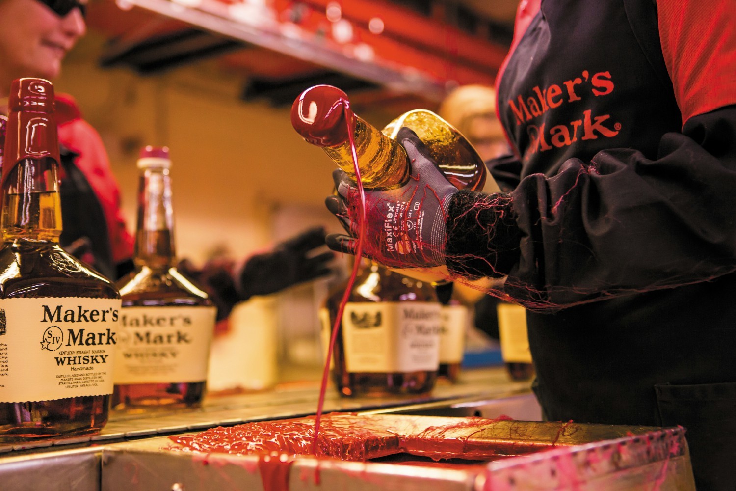 Maker's Mark bottles being dipped in wax at the distillery. 