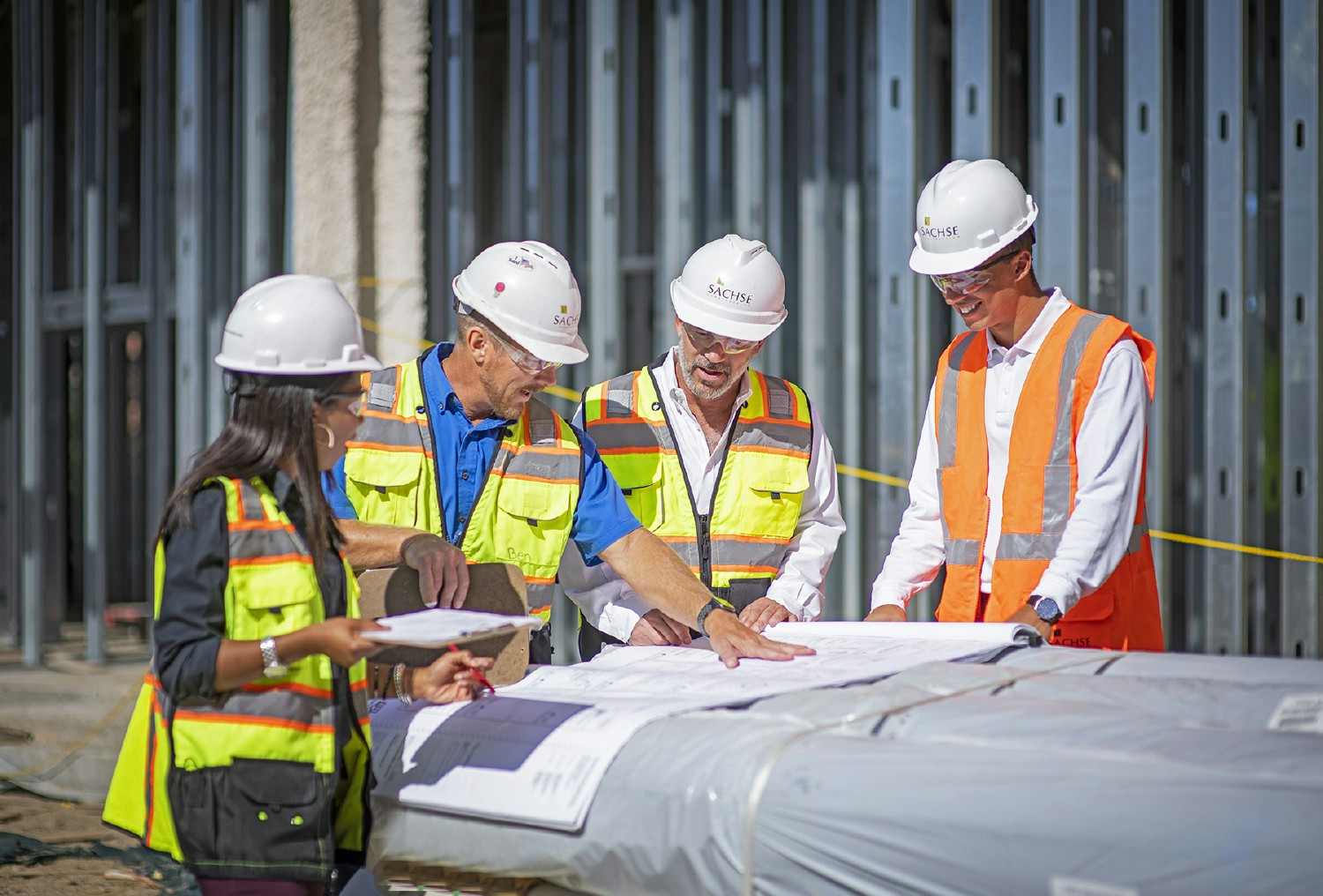 Project team members are reviewing the plans for a mulitfamily development at the jobsite.