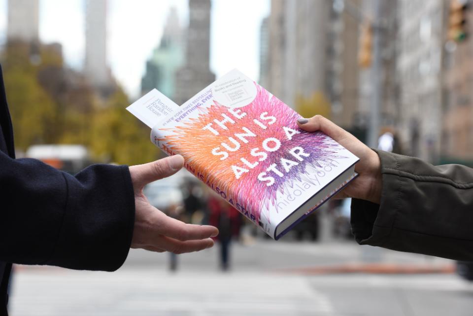 A PRH employee hands out a book to a NYC pedestrian for our 2017 #GiveABook campaign.