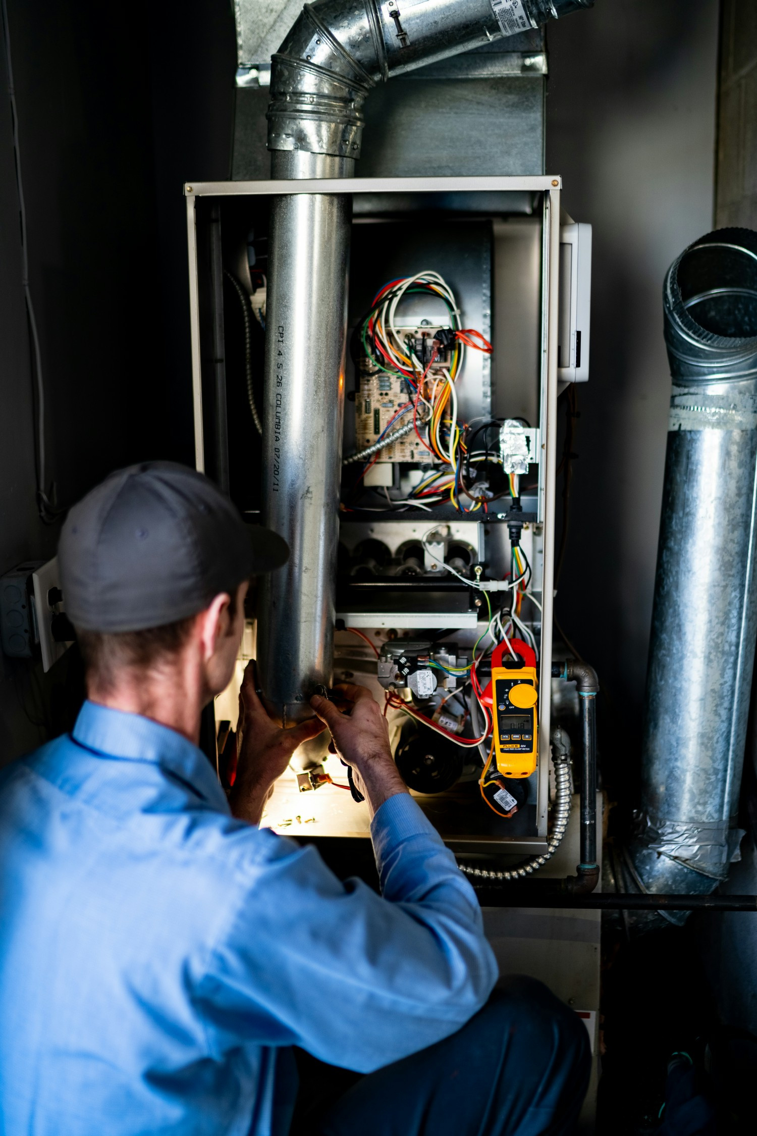 We provide preventative maintenance! Pictured is a Pacific Technician performing a precision tune-up on a heating unit