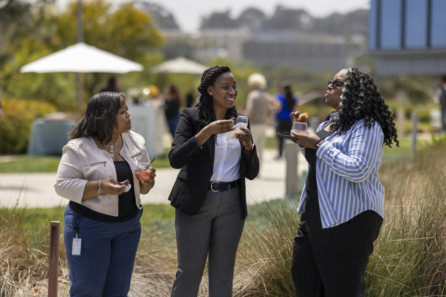 A Vertexian, smiling among colleagues, represents the excitement in our offices day-to-day