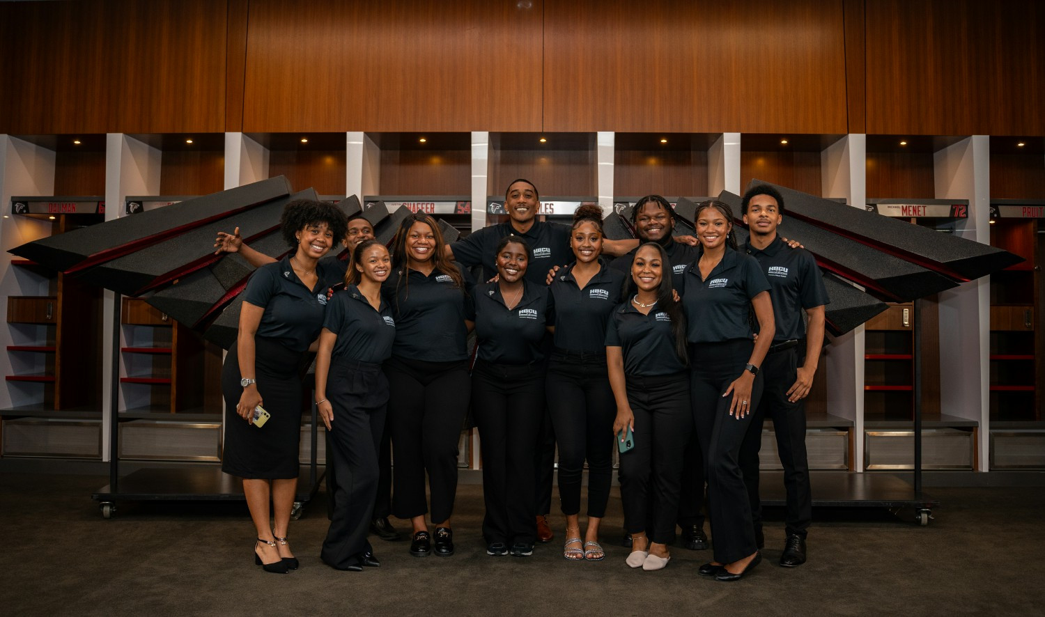 Recognized event-day team members celebrate with leadership by the Heroes of Hospitality mural at Mercedes-Benz Stadium.