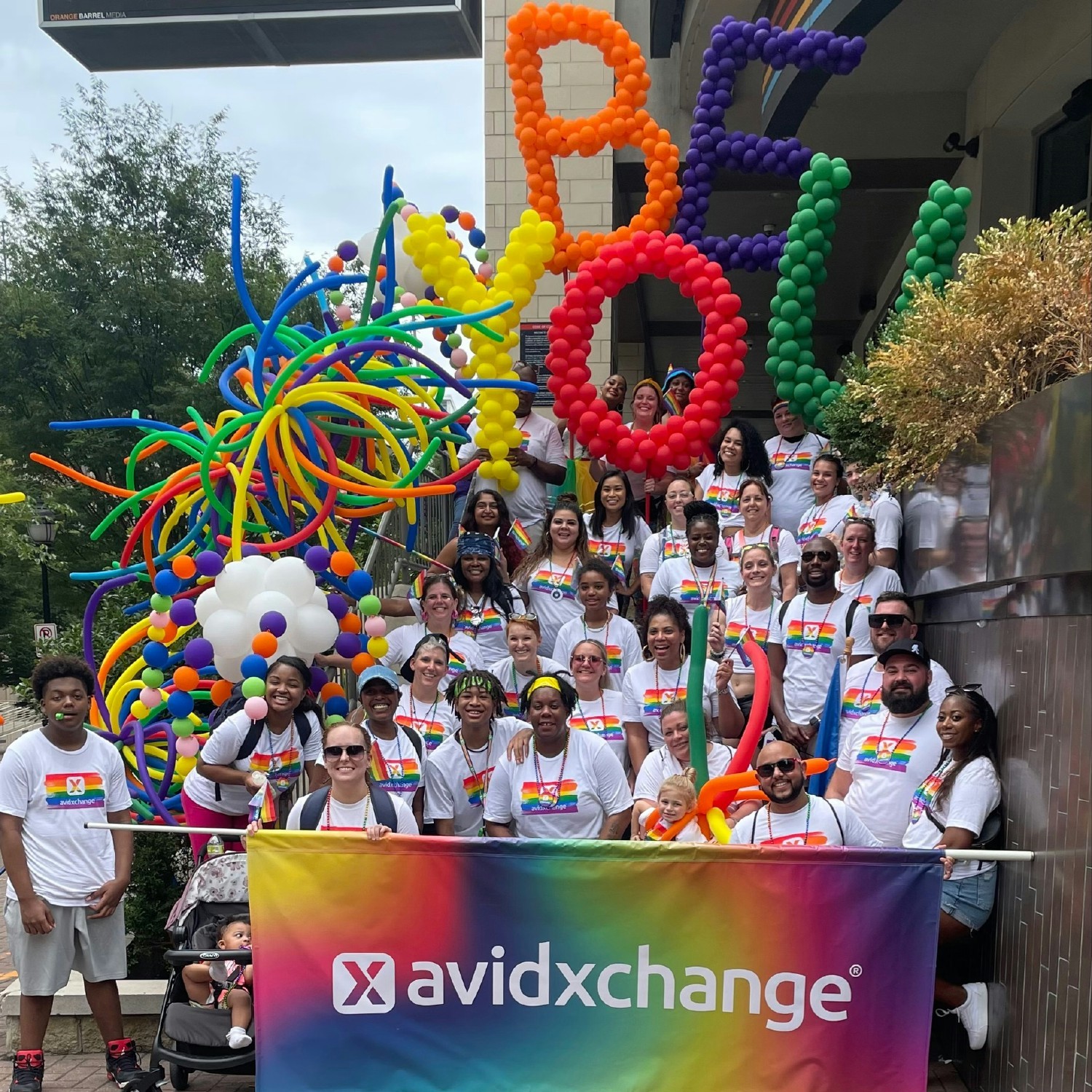 AvidXchange teammates celebrate Pride Month with a banner/balloons as a part of our float in the Charlotte Pride Parade.
