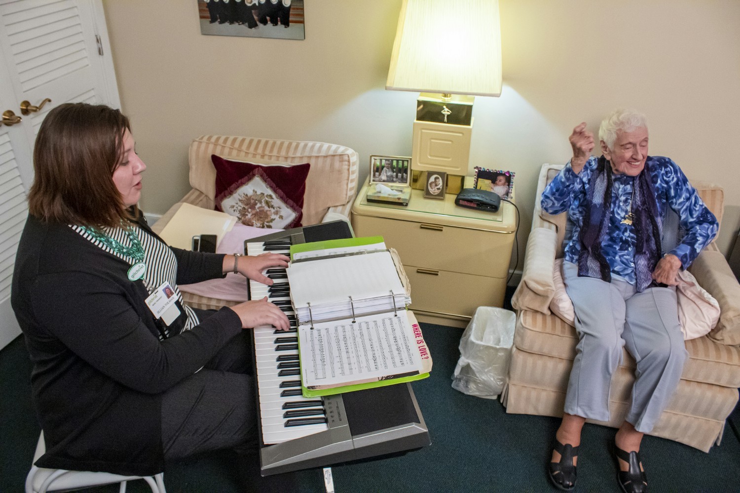 Gilchrist's Music Therapist sings and plays a hospice patients favorite song while the patient sings and kicks her feet,