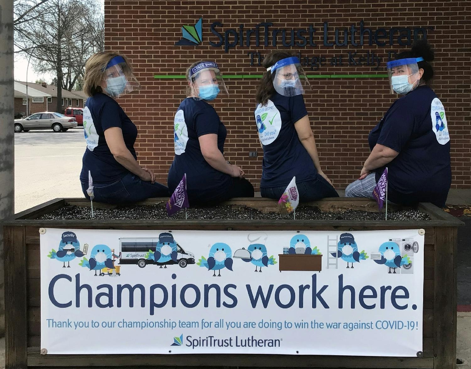 Team members proudly display shirts announcing they received their first shot of the COVID-19 vaccine.