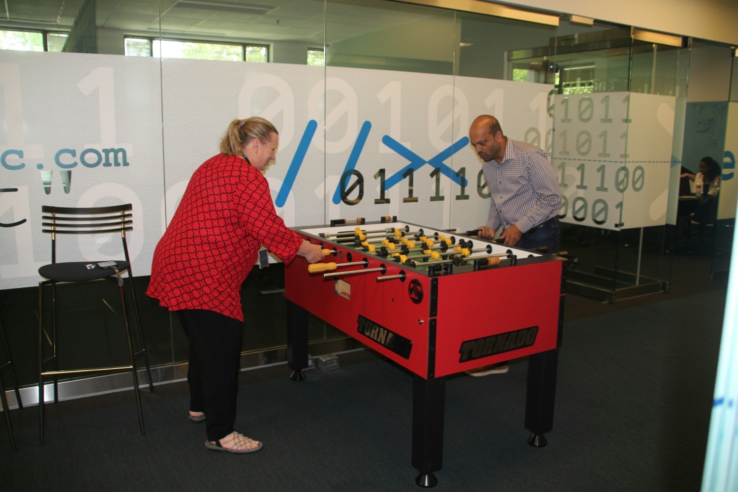 Employees playing a competitive Foosball game
