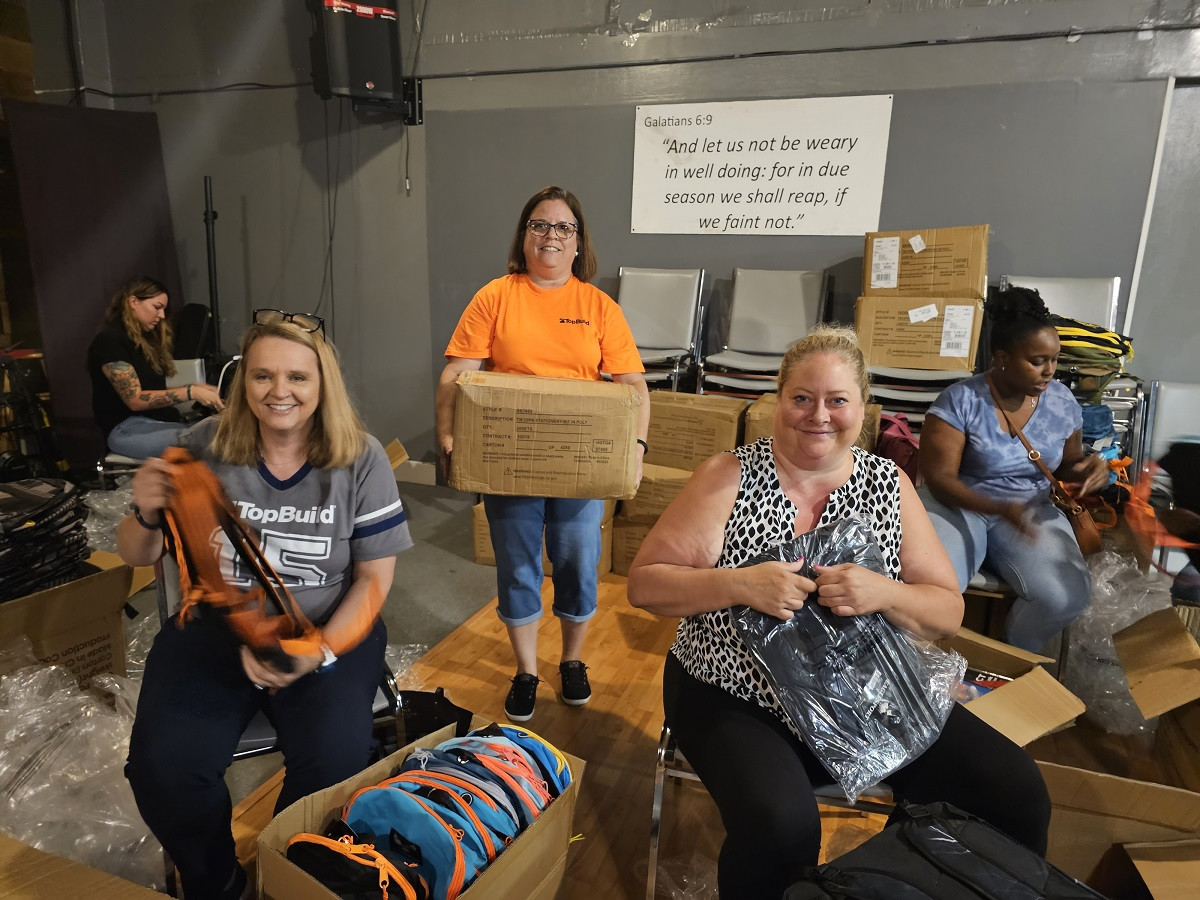 Employees helping fill backpacks with school supplies for our Annual PayItForward Backpack. 