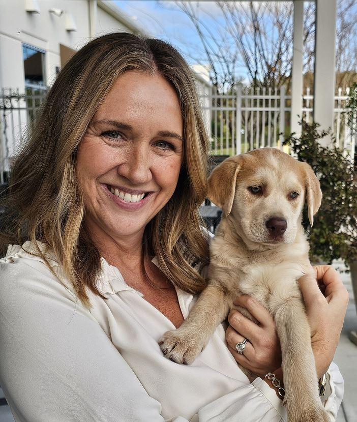 TopBuild's CHRO holding a puppy that was brought in by Sophia's Circle a dog rescue organization that visited BSC