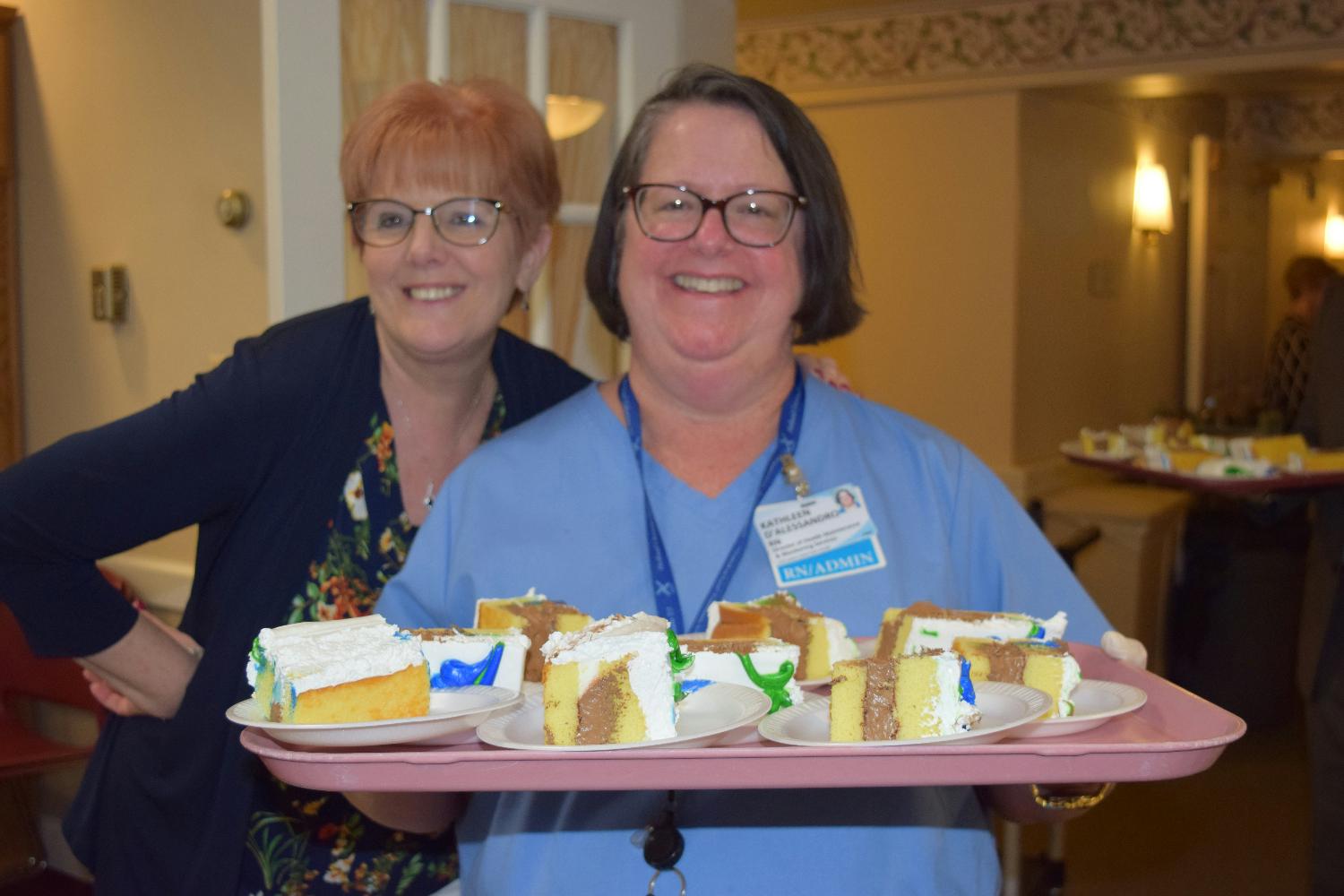 Staff get in on the fun by serving cake to residents at a party.