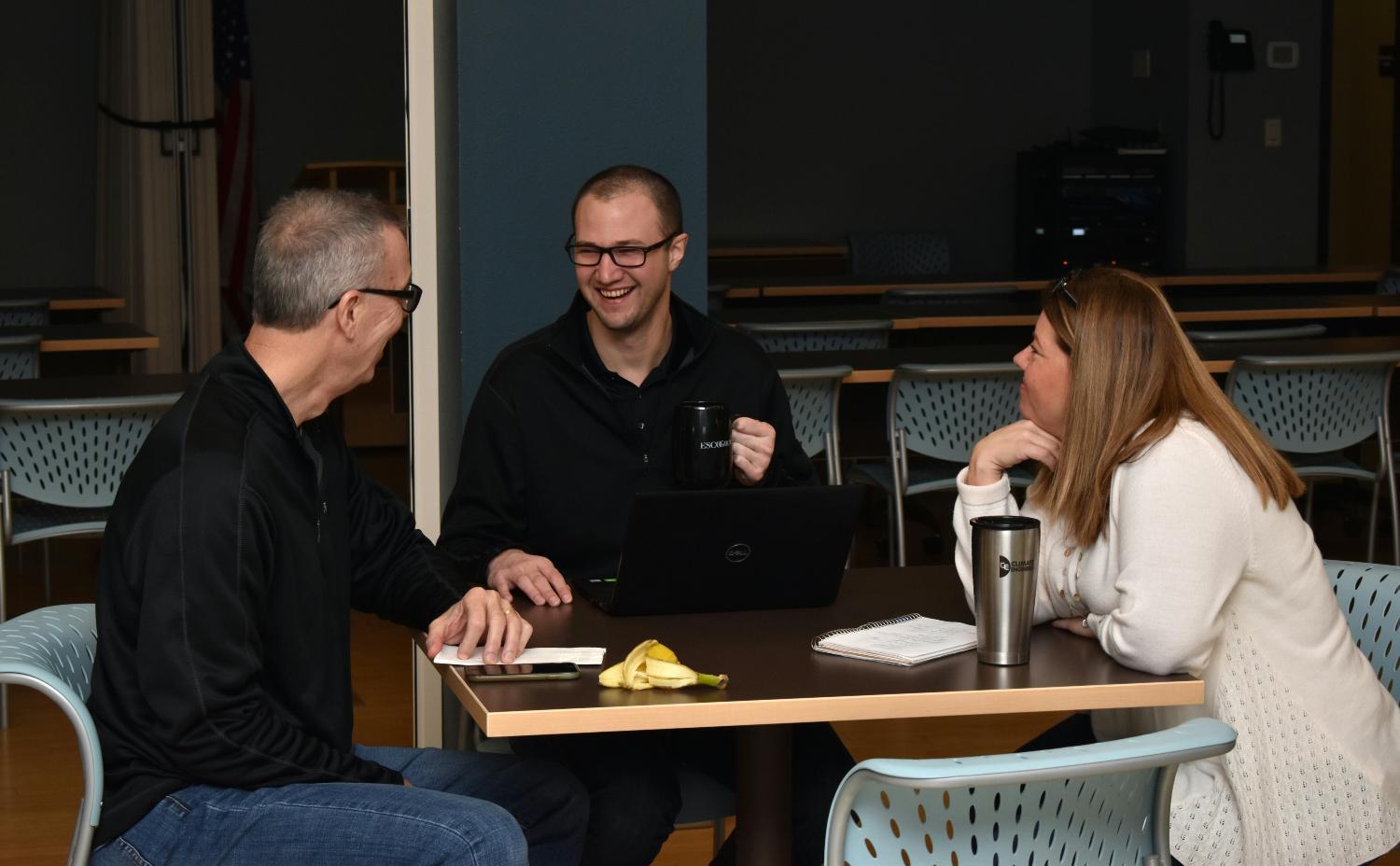 Ryan, Dan, and Angie share a good chuckle as they have a morning snack at ESCO's monthly meeting, 