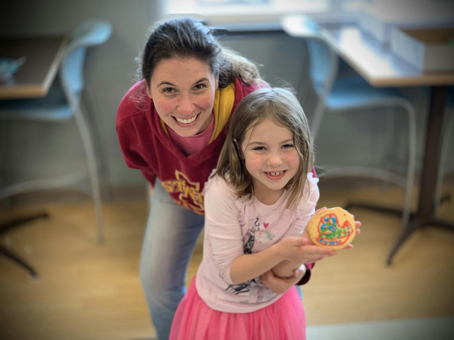 Jennifer and her daughter show off their artwork at ESCO's family holiday cookie decorating day.