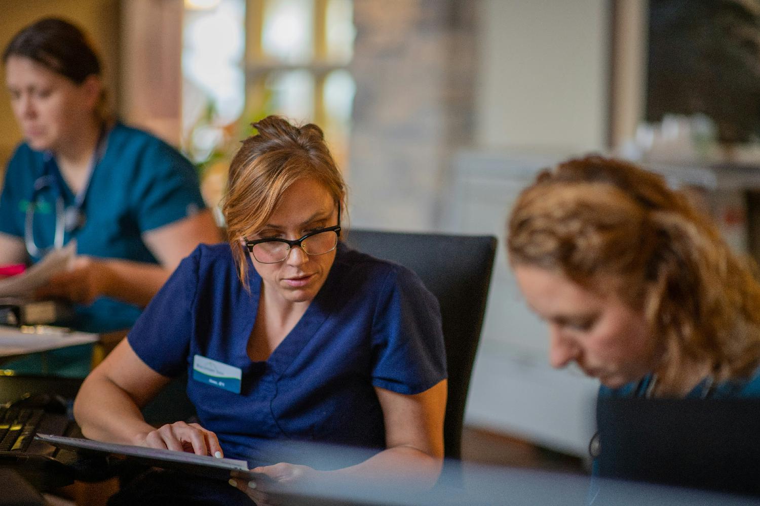 Eduro Healthcare nurses charting notes on patient care.