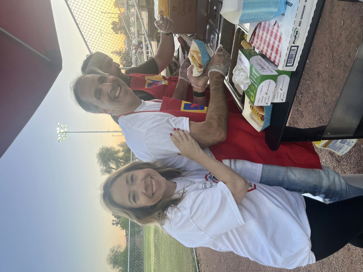 Mark and Alexis serving our team members and their families hot dogs