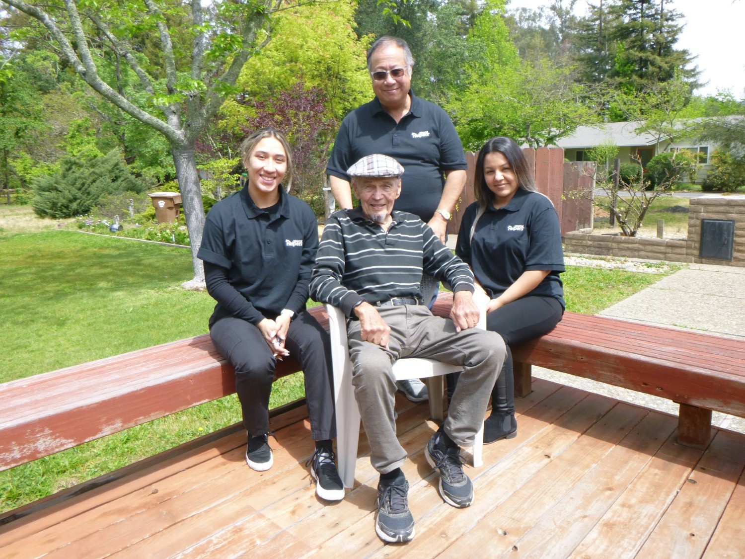 Senior Helpers client with his caregiving team in his backyard