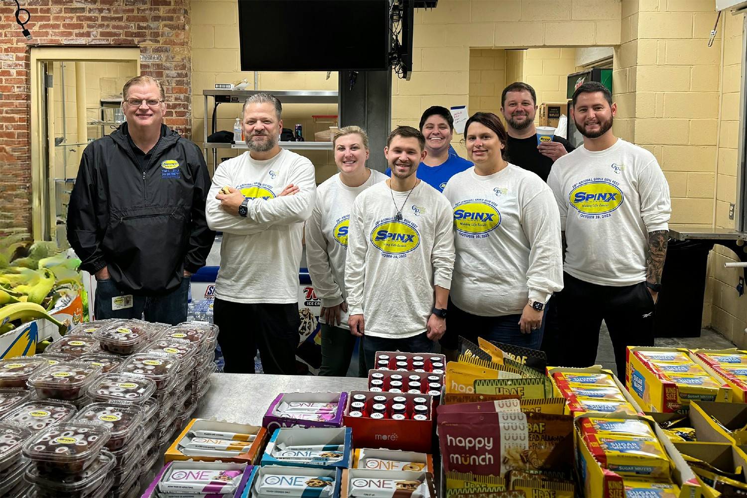Teammates eagerly assembled, brimming with enthusiasm, to distribute snacks at the Spinx-sponsored Run Fest.