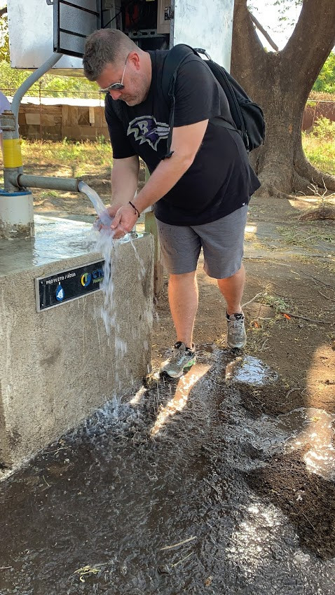Reynolds using a clean water well CTG Foundation installed at a school to give clean water to more than 200 students