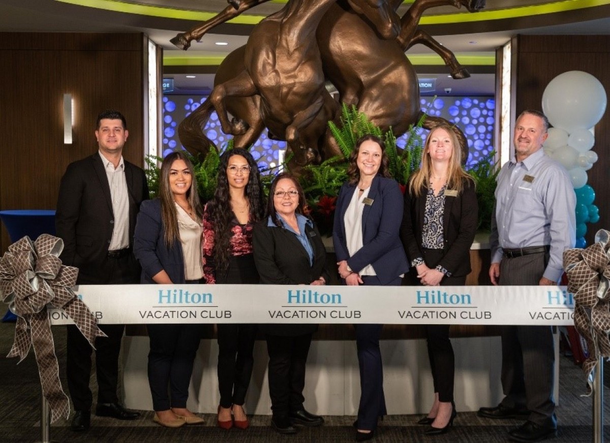 HGV team members celebrating a ribbon-cutting ceremony under the new Hilton Vacation Club collection. 