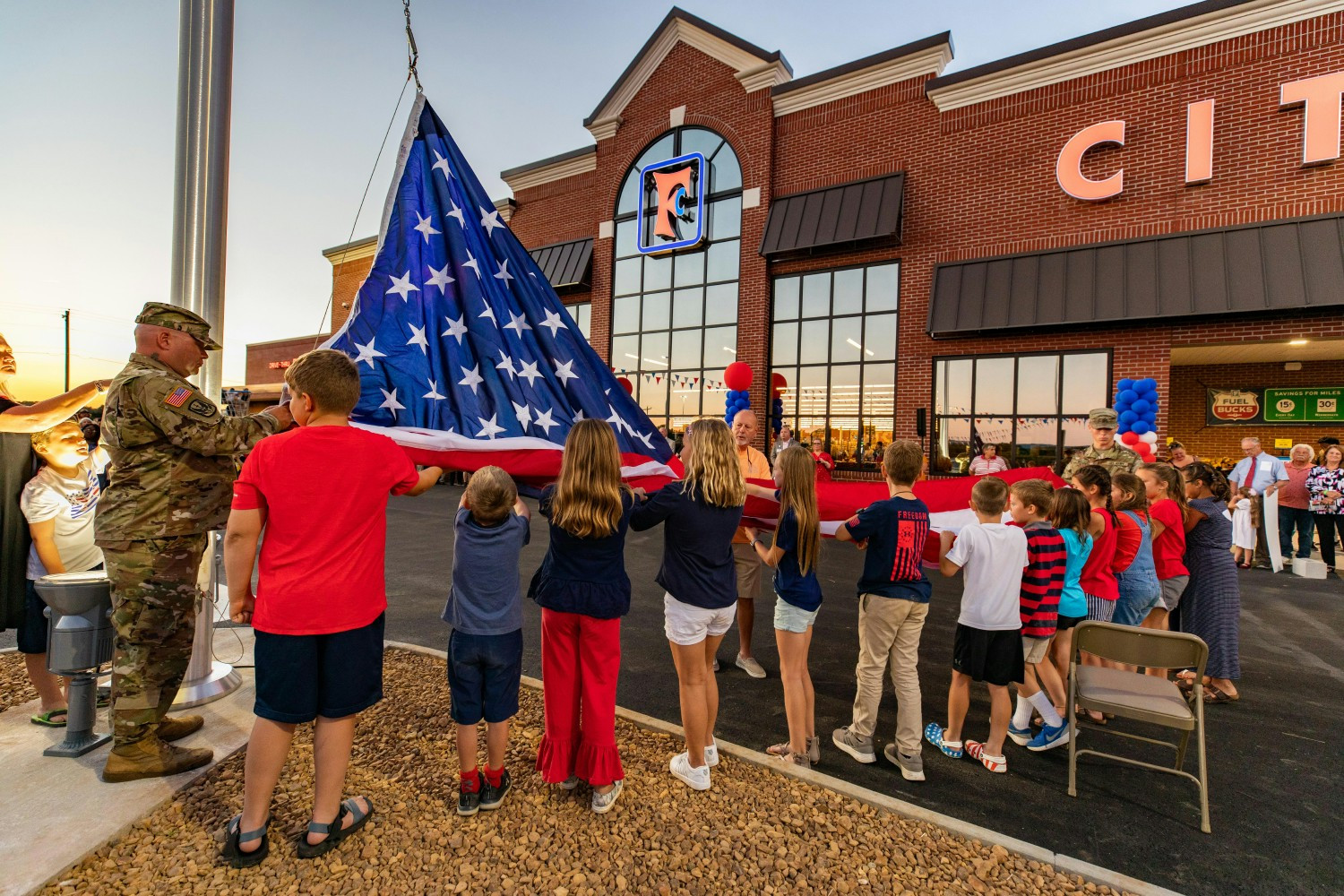 Community members help raise the flag at Food City Grand Opening. 