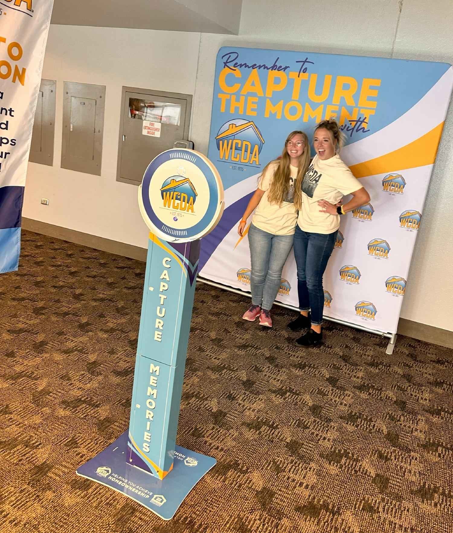 WCDA team members posing at a new company-branded selfie station. 